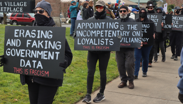 protesters in black holding anti-facist signs